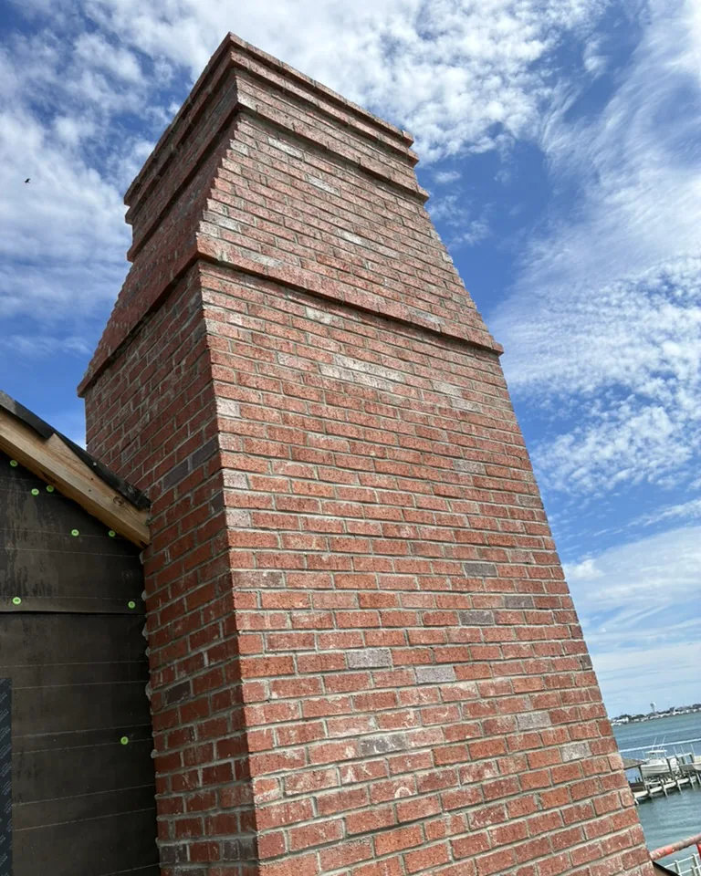 Brick chimney completed by Vic’s Bricks against a blue Eastern North Carolina sky