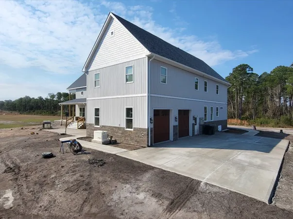 New concrete driveway and parking slab beside a house