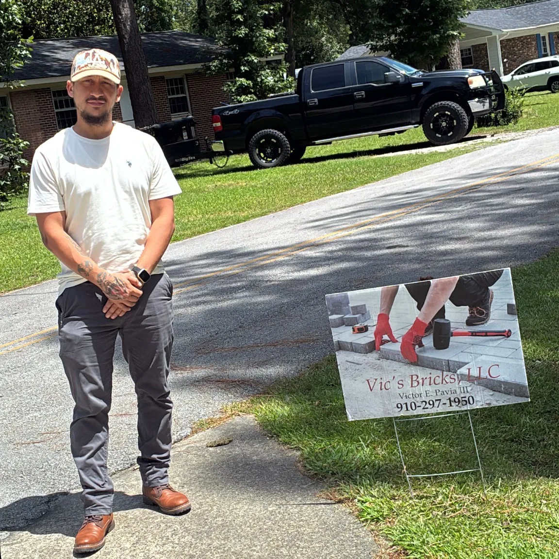 Vic, owner of Vic's Bricks, beside his work truck and business sign